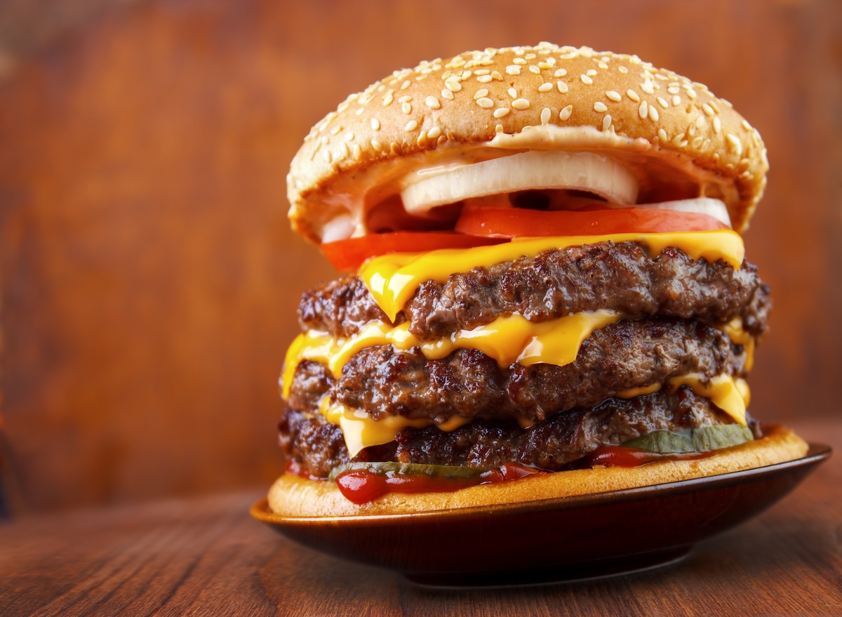 Big,Beef,Burger,With,Three,Patties,And,Cheese,On,Plate