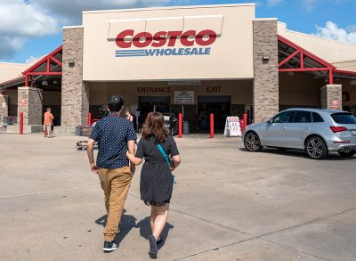 Costco Wholesale storefront with customers walk in.
