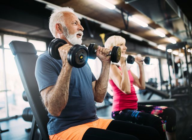 Happy senior people doing exercises in gym to stay fit