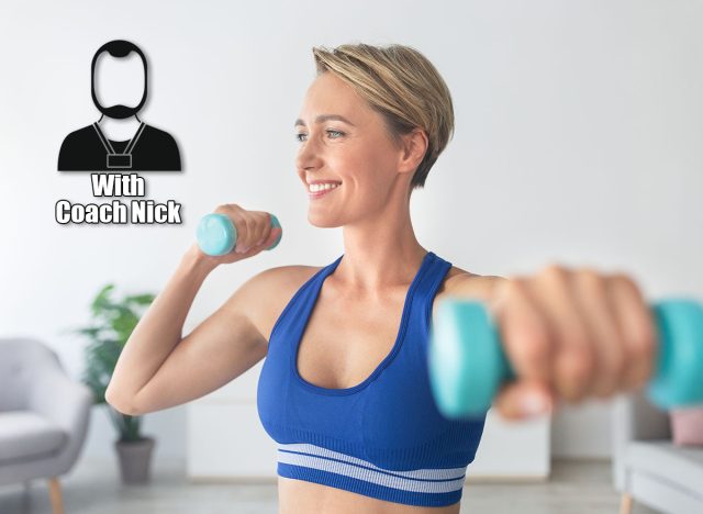 5 Quick Fixes To Beat Grip Fatigue and Lift Heavier, According to a Trainer. Domestic Fitness Concept. Portrait Of Smiling Adult Woman In Sports Bra Exercising With Two Dumbbells Posing At Home, Enjoying Workout, Looking Away. Selective Focus, Blurred Background. Cover