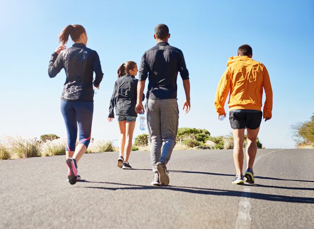 People, friends and walking exercise as group or running community for club sports, hiking or nature. Men, women and back for healthy cardio in California for outdoor training, workout or athlete