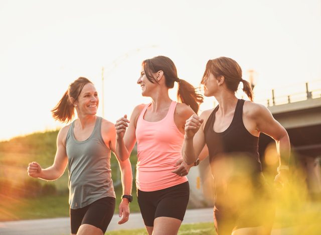 The females in sportswear walking together bright sunny park in summer