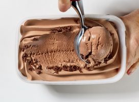 chocolate ice cream is scooping out of container, top view