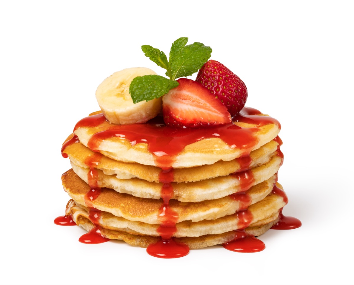 Pancakes with fresh strawberries and syrup Isolated on white background