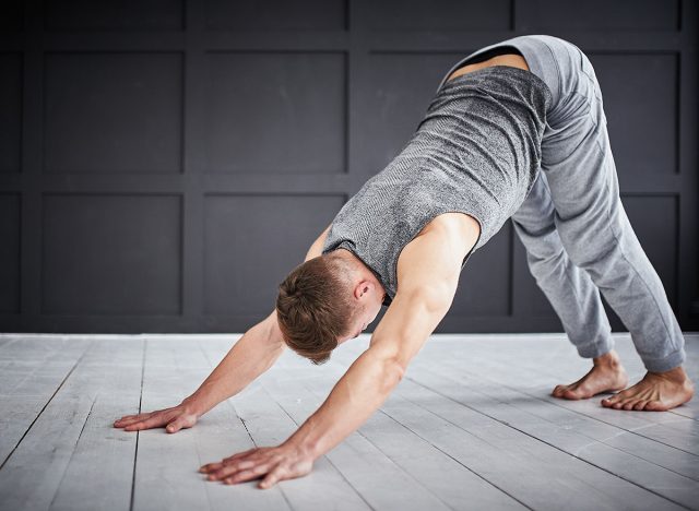 Young strong man practices yoga at the yoga studio