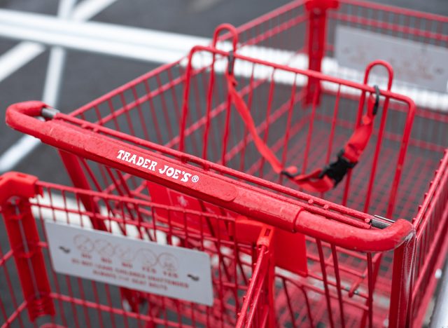 Close up on a Trader Joe's shopping cart handle, with space for text on top
