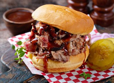 BBQ smoked pulled pork sandwich with pickles and barbeque sauce
