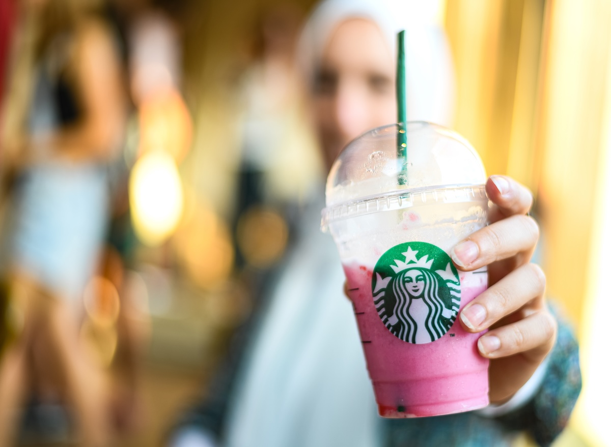 A,Holding,A,Starbucks,Cup,Of,Cold,Beverage,Made,O