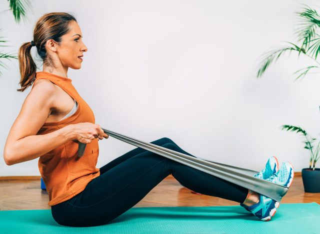 Woman Exercising with Elastic Band. Rowing Exercise Strength Training.