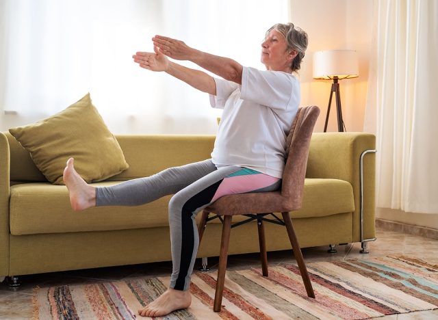 Senior caucasian woman doing yoga at home on chair
