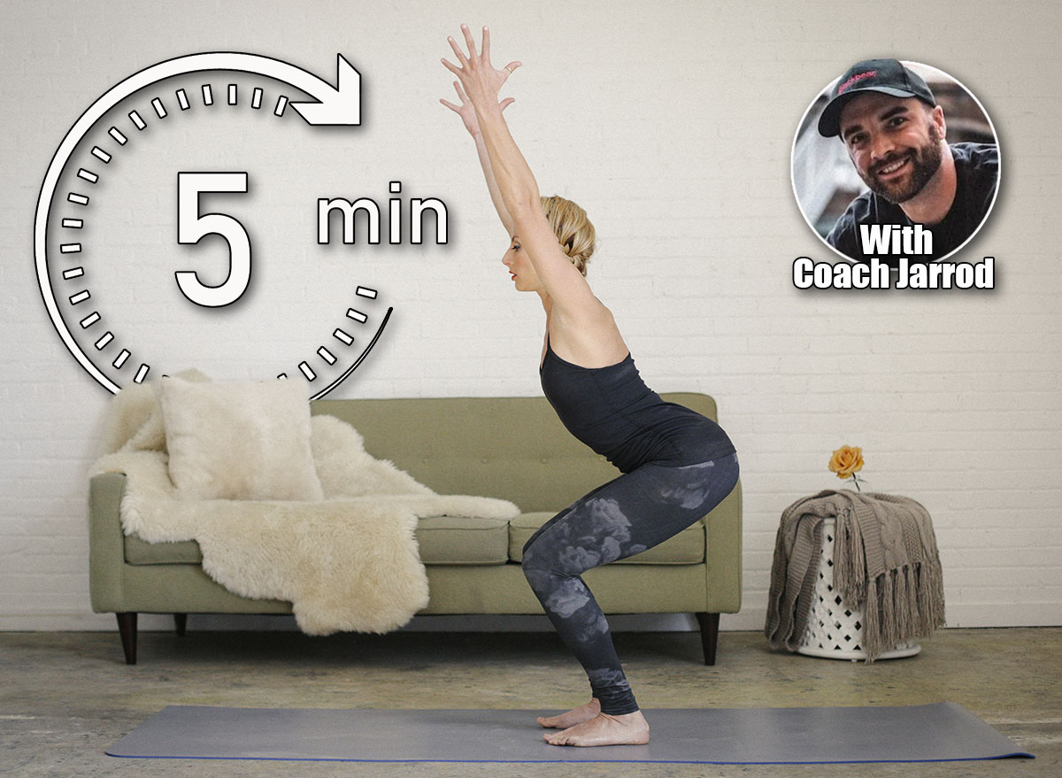 A blonde woman in a black leotard and leggings, standing on a yoga mat in a room, doing yoga, squatting down with her arms raised. This 5-Minute Morning Routine Builds More Strength Than Hour-Long Workouts After 50. Cover