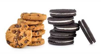 Chocolate chip and sandwich cookies with cream on white background