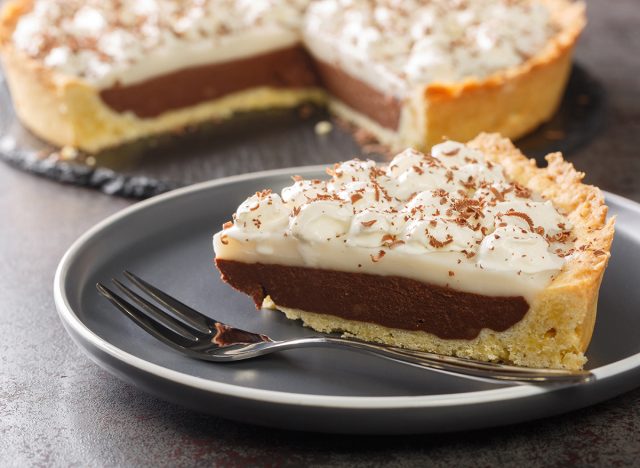 Coconut Haupia and Chocolate Pie topped with whipped cream closeup in the plate on the table. Horizontal