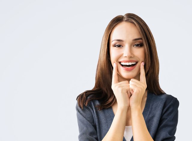 Dental dent health care ad concept picture - brunette beautiful woman in casual cloth show white toothy smile. Portrait image of happy girl, isolate bright gray wall background wide banner composition