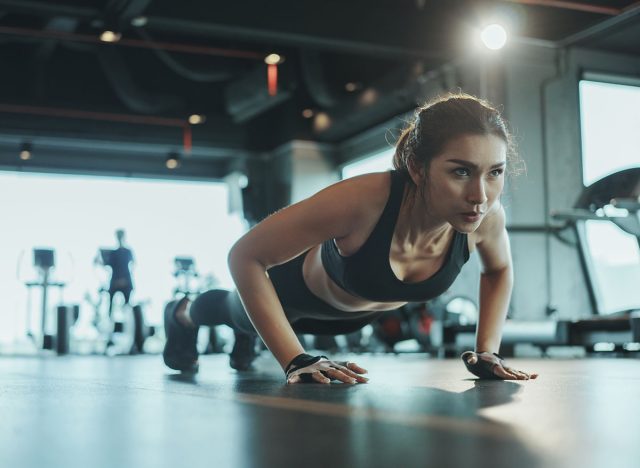 Sporty woman performing push-ups from the floor in the gym.