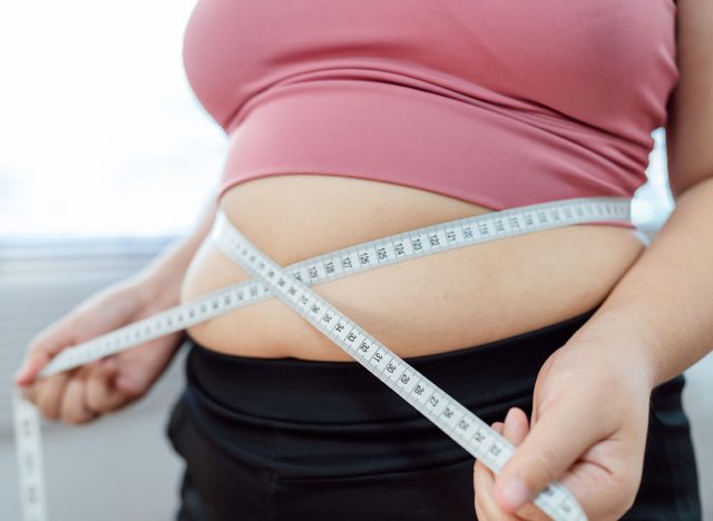 Obese Woman with fat upset about her belly. Overweight woman touching his fat belly and want to lose weight. Fat woman worried about weight diet lifestyle