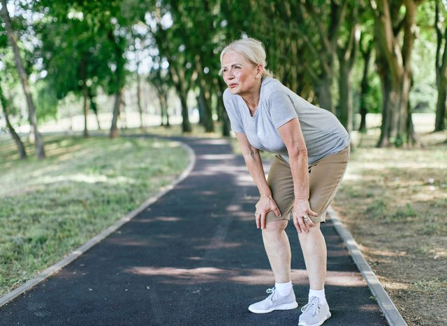 Portrait of an active beautiful senior woman tired and exhausted resting and making a break after exercicing outdoors in park