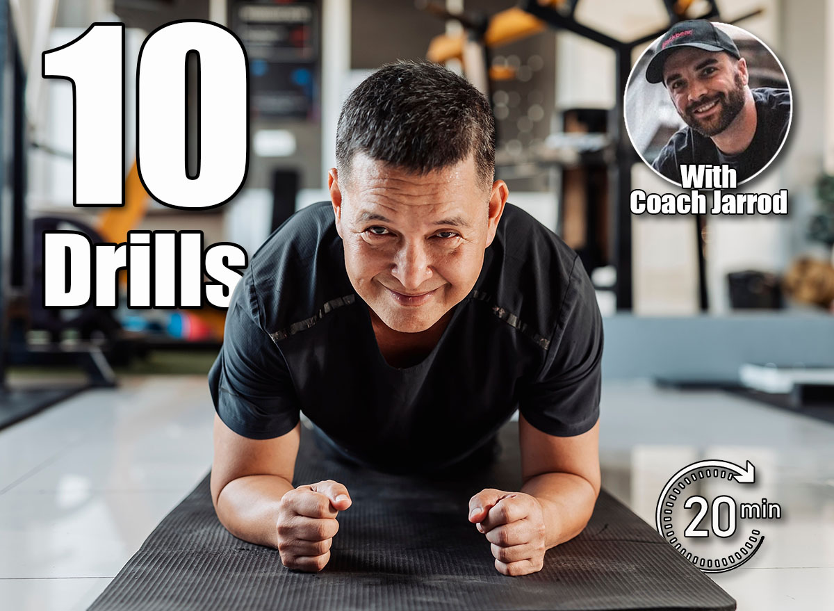 Southeast Asian man in his 50s holds a plank on mat with a confident smile, demonstrating strength and stability in core training. Over 50? If You Can Do These Strength Drills, You’re in Great Shape. Cover,