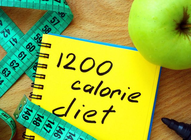 Notepad with 1200 calorie diet, apple and measure tape