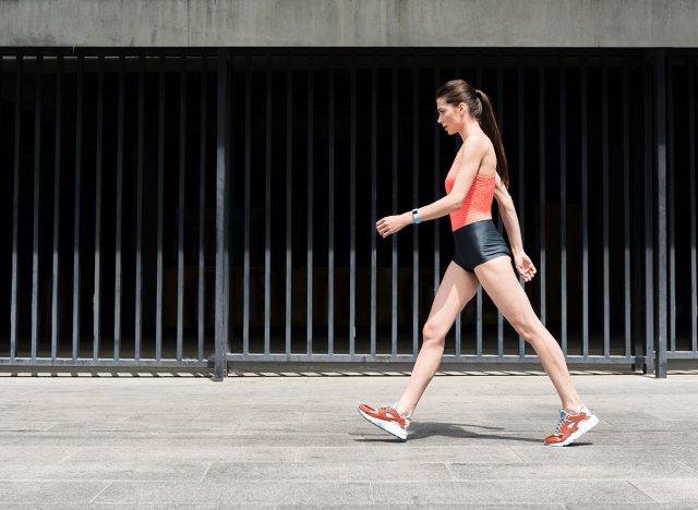 Slim sporty young girl walking on street