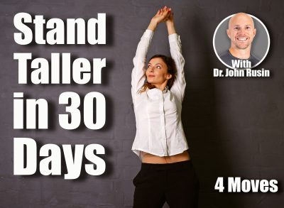 Young brunette woman in white shirt raises hands on dark background. 4 Classic Standing Exercises That Fix Your Posture in 30 Days After 40. Cover