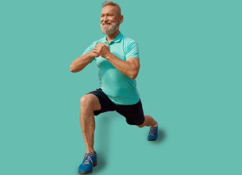 Senior man doing lunges physical exercises at sport field outdoors