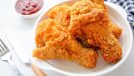 Fried crispy Chicken Drumsticks in white plate with tomato sauce on white background