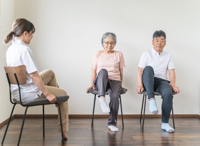 Seniors and elderly men and women doing chair exercises, exercise, and rehabilitation at a nursing home, and exercise instructors and health exercise instructors (legs)