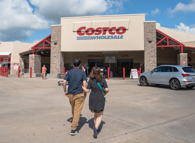 Costco Wholesale storefront with customers walk in. Costco Wholesale Corporation is largest membership-only warehouse club in US. It has a total of 705 warehouses worldwide