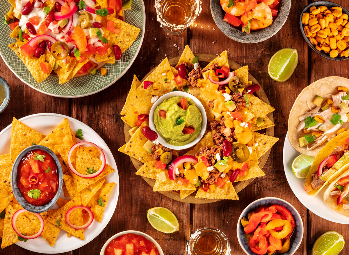 Mexican food variety, shot from the top on a rustic wooden background. Nachos, guacamole, tequila, tacos, a flat lay