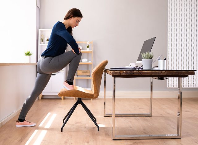 Smiling Young Female Manager Sitting On Chair Stretching Her Arms
