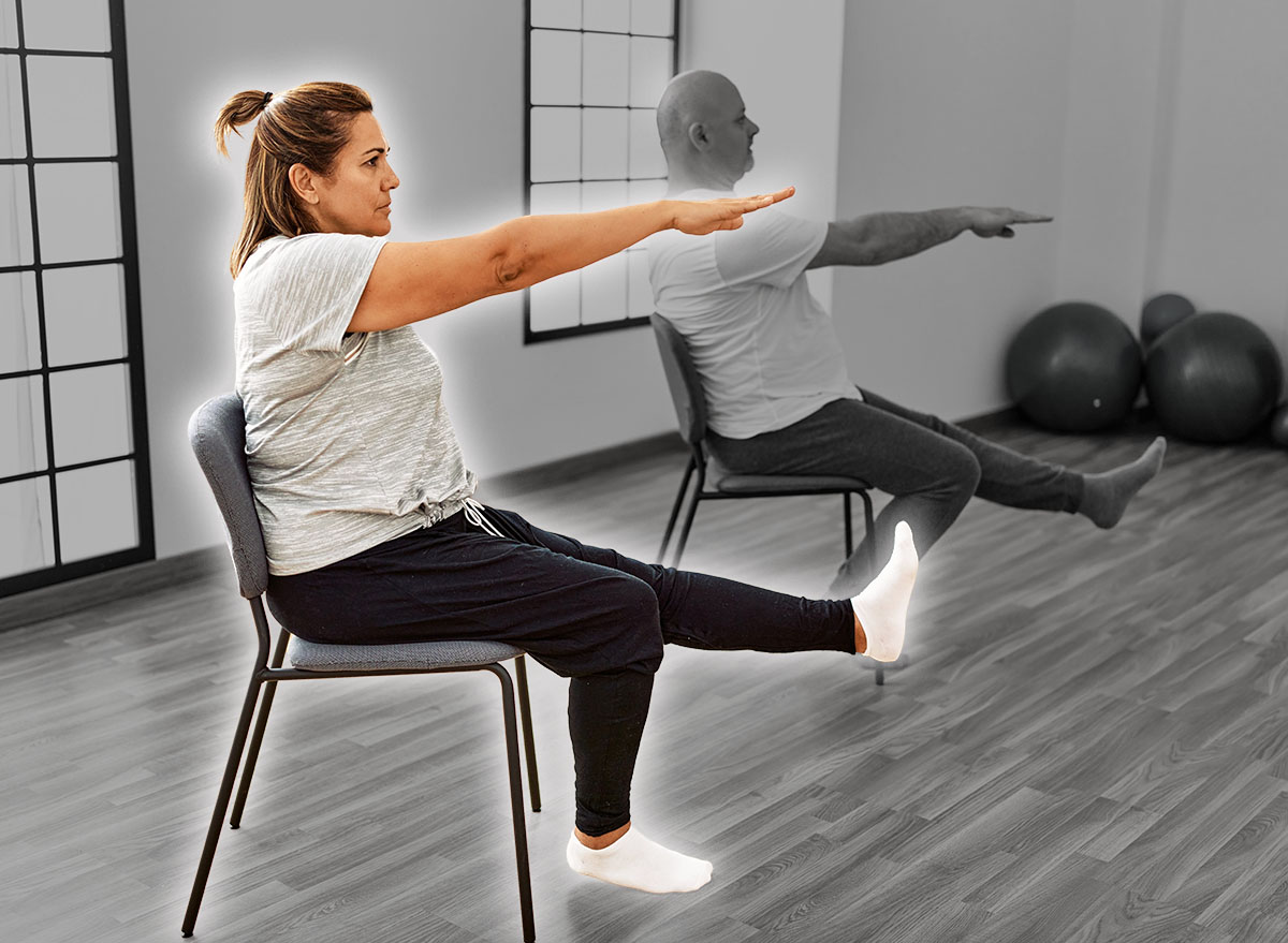 Middle age hispanic couple stretching using chair at sport center.