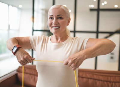 Cheerful blonde lady doing an upper-body exercise