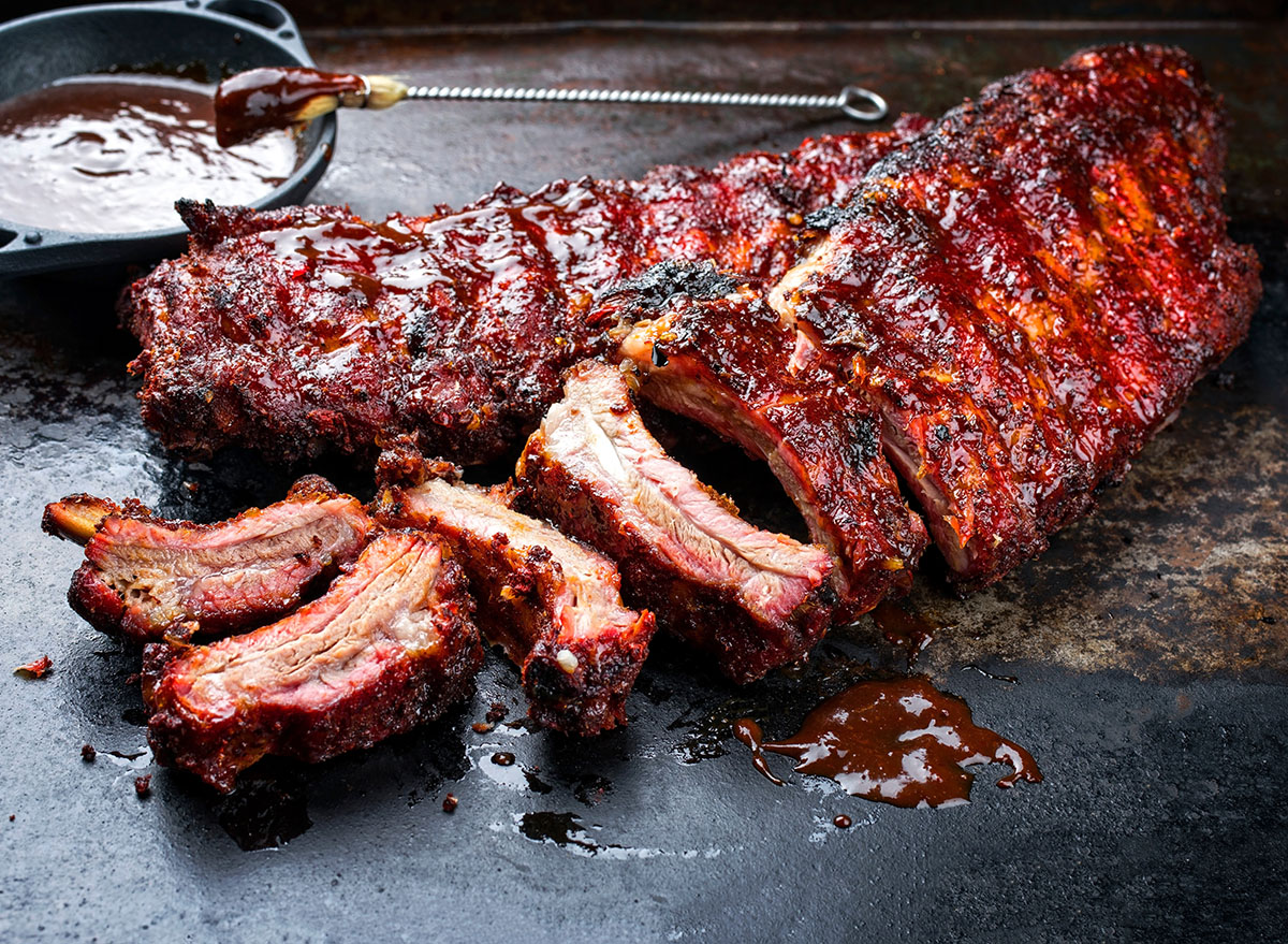Barbecue pork spare loin ribs St Louis cut with hot honey chili marinade burnt as closeup on an old rustic board
