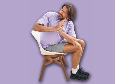 Middle age man smiling confident sitting on chair stretching at sport center