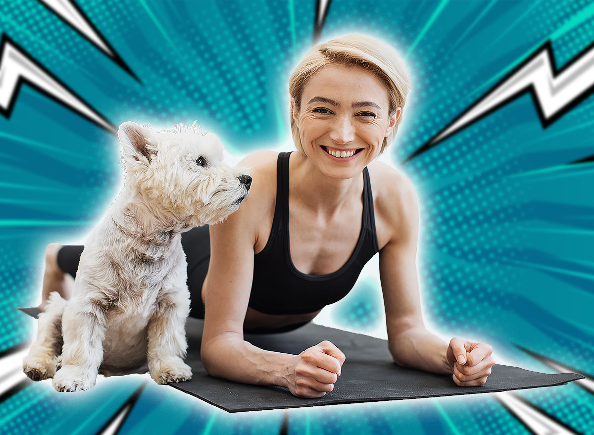 Portrait of happy blonde woman snuggling to adorable little dog while holding Forearm Plank Pose at home. Beautiful slim lady leading healthy lifestyle doing yoga whilst caring for furry friend.