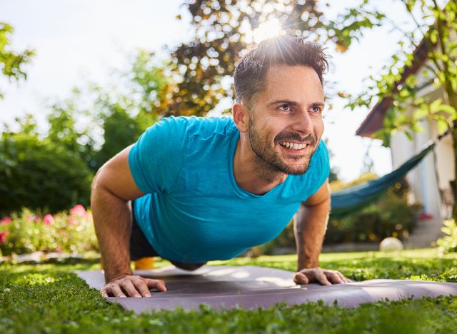 Smiling man doing pushups in the backyard garden. 6 Simple Moves That Build More Muscle Than Expensive Equipment After 40. Cover