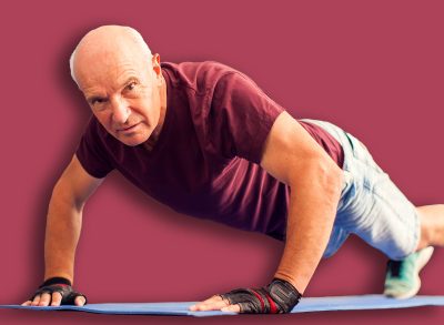 A portrait of bald senior man doing pushups exercise in the gym. People, healthcare and lifestyle concept