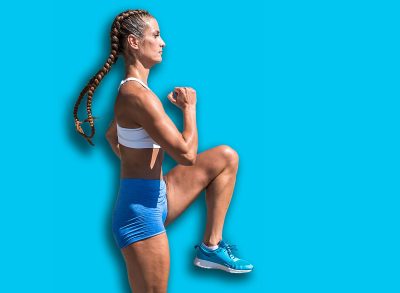 Young active strong sexy muscular fit woman in shorts doing high knee skip running in the place as hard outdoor cross workout training real people exercising