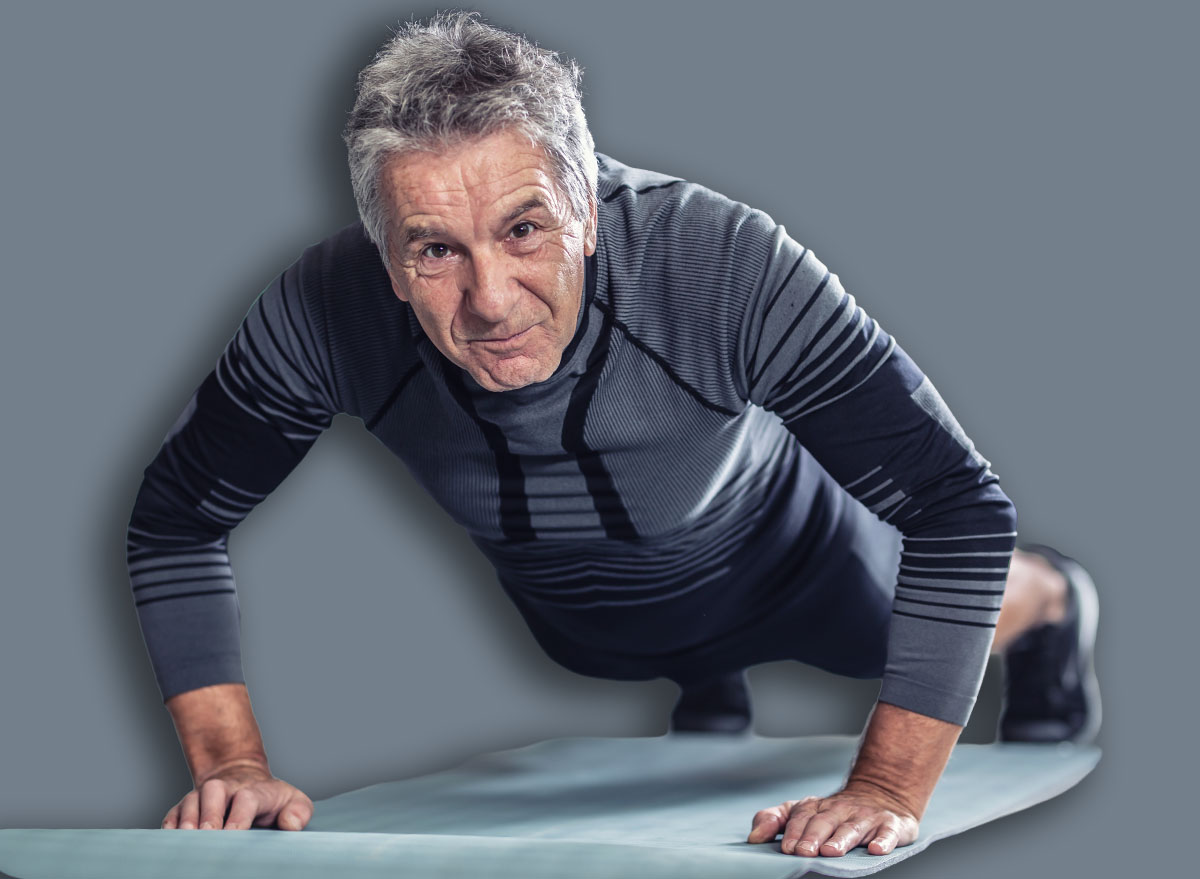 Age is just a number to a man with grey hair doing pushups in a gym.