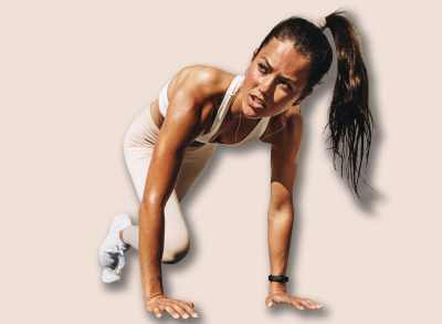 Healthy woman doing mountain climbers exercise. Female in sportswear exercising on a mat outdoors.