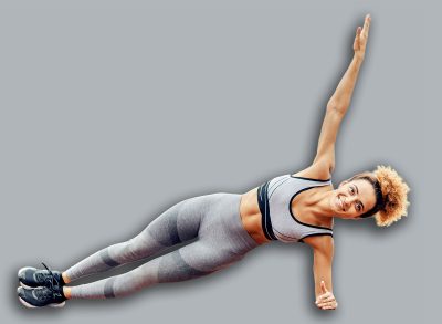A fit, strong, muscular woman doing side planks in the stadium in rainy weather. A sportswoman practicing in the stadium.