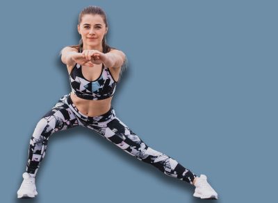 Woman doing walking lunges outdoors overlooking the river. Fitness, sport and healthy lifestyle concept.