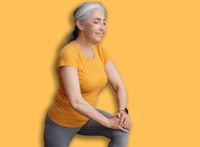 Positive sporty senior woman keeping fit at home, doing lunges, exercising on yoga mat in living room and smiling. Staying healthy at retirement