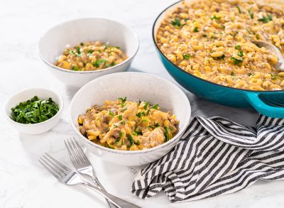 Serving homemade hamburger helper in white ceramic bowls.