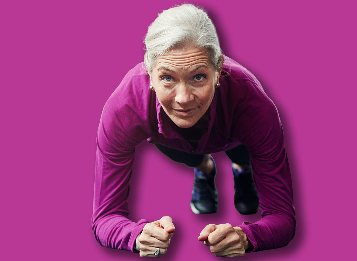 Mature woman, plank and gym on floor with balance for strong core muscle with vision for wellness. Person, training and workout for abdomen, stomach and challenge for development at fitness club