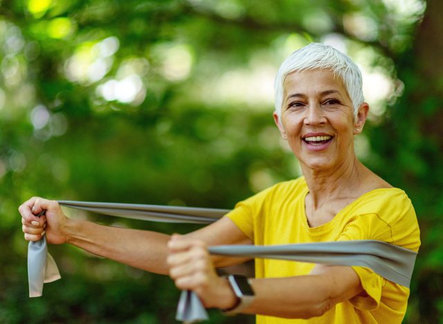 Senior woman exercising with resistance band for effective exercise in the park.