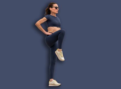 Sporty woman stretching leg muscles with standing single knee to chest stretch