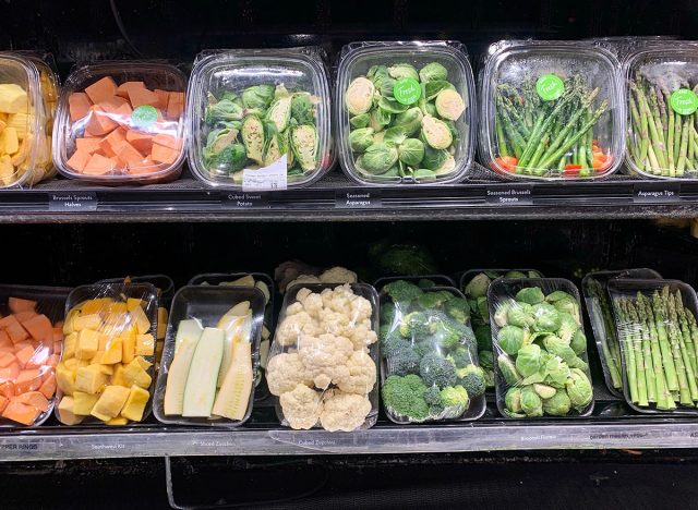 A selection of precut produce including brussels sprouts, sweet potatoes, asparagus, zucchini and broccoli.