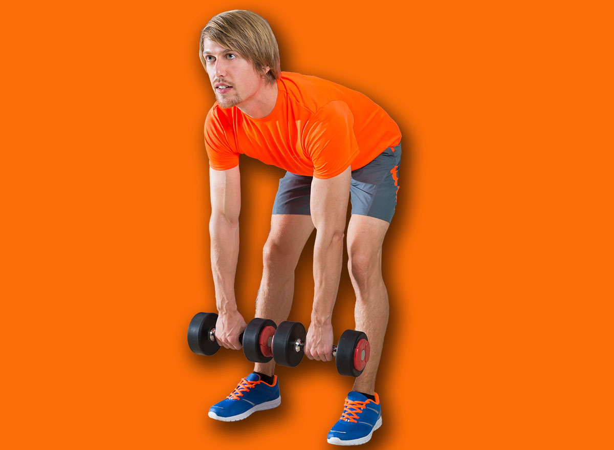 dumbbell deadlift blond man at gym weightlifting with swiss ball background